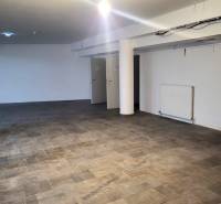 Commercial spaces with wood-patterned flooring and white walls.