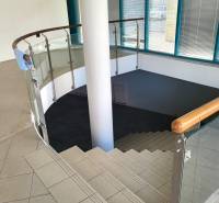 A staircase with glass railing leads to the lower part of the commercial premises.