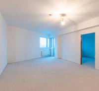 A spacious room in a 2-room apartment with white walls and lighting.