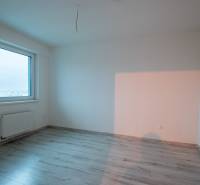 A bright room with a large window and a wooden decor floor in a 2-room apartment.