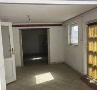 The interior of a family house with tiles and windows that let in light.
