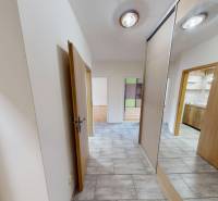 Entrance hallway of a 3-room apartment with a tiled floor and sliding doors with a mirror.