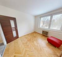A room with large windows, a wooden decor floor, and double doors in a 3-room apartment.