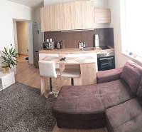 1-bedroom apartment with a kitchenette, sofa, TV, and wooden-style flooring.