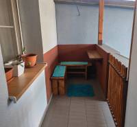 A balcony with wooden furniture and plants in a studio apartment.