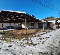 A warehouse structure and a snowy road in Medzany.