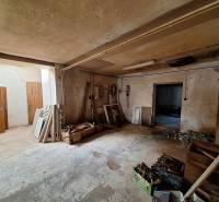 Interiors of warehouses and halls with stored wood and various building materials.