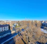 A view of a district in Poprad with residential buildings and a road in the winter season.