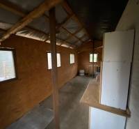 Interior of a cabin with wooden decor and windows, without visible furnishings.