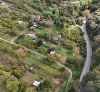 Garden area with cottages around Hlohovec surrounded by greenery and a road.