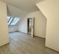 A studio apartment with a wooden decor floor and skylights.