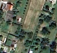 Aerial view of residential plots in Hlohovec with gardens and houses.