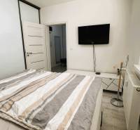 Bedroom in a 3-room apartment with a TV, wardrobe, and bed.