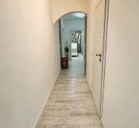 A hallway with pale tiles and white walls in a 3-room apartment.