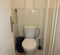 Small bathroom with toilet and tiles in a studio apartment.