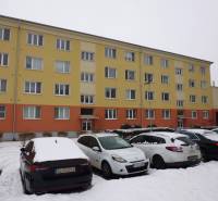 In the snowy city of Prešov on 17th November Street, there is an apartment building with a parking lot.