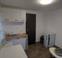 A kitchen in a cottage with a table, chairs, and a floor with a wooden decor.