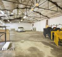 A spacious interior area with a car, chairs, and storage shelves.