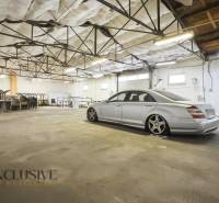 A car parked in commercial premises with an industrial ceiling and storage space.