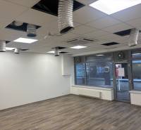 Commercial premises with wood-patterned flooring and ceiling ventilation.