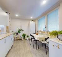 A bright kitchen with wood-patterned flooring, a dining table, and decorative elements in a studio apartment.