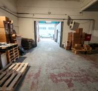 Warehouses and halls with a multitude of cardboard boxes and pallets on a worn-out floor.