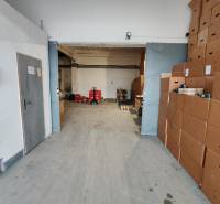 Warehouses and halls with cardboard boxes and pallets, metal doors, concrete floor.