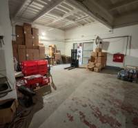 Warehouses and halls with stacks of cardboard boxes and red crates.