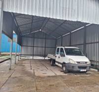 The car is parked under a metal shelter in the area of Warehouses and Halls on Lieskovská Road in Zvolen.