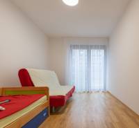 A room in a 3-room apartment with a sofa and a bed, a floor with a wooden decor.