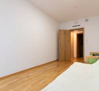 A room in a 3-room apartment with white walls and a floor with a wooden decor.