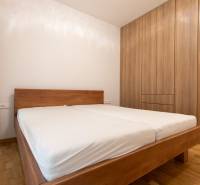 Bedroom in a 3-room apartment with a bed and a wardrobe, floor with wooden decor.