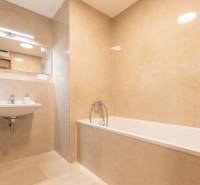Bathroom with a bathtub, sink, and large mirror in a 3-room apartment.