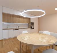 A kitchen in a 3-room apartment with a table and a wooden decor floor.
