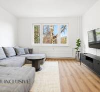 Living room with a large sofa, television, and wooden decor flooring in a 3-room apartment.