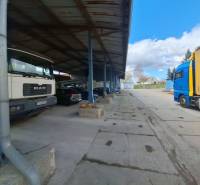 On Lieskovská cesta street, warehouses and halls with trucks parked under the roof.