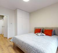 Bedroom in a 2-room apartment with a bed, sliding doors, and storage space.