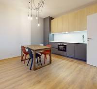 Kitchen in a 2-room apartment with wooden decor and a dining table.