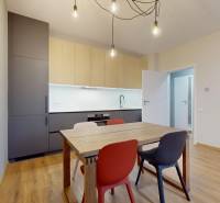 Dining table and kitchen unit in a 2-room apartment with a wooden decor floor.