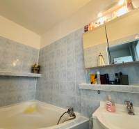 Bathroom in a 3-room apartment, blue tiles, bathtub, mirror cabinet with lighting.