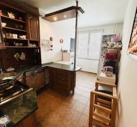 A kitchen in a 3-room apartment with brown furniture and ceramic flooring.