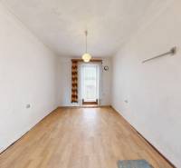 Interior of a family house with a wooden decor floor, curtain, and hanging light fixture.