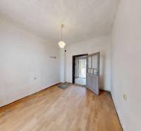 A room in a family house with a wooden decor floor and a pendant light.