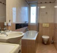 Bathroom with a bathtub, sink, toilet, and washing machine in a 3-room apartment.