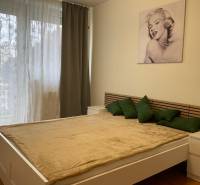 Bedroom in a 3-room apartment, bed with wooden decor and artwork on the wall.