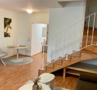 Interior of a 3-room apartment with a wooden decor floor and a staircase.