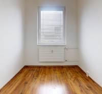 A room in a 3-room apartment with white walls and a wooden decor floor.