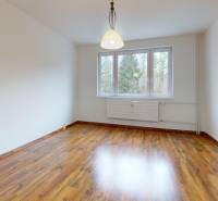 A room in a 3-room apartment with wooden floor decor and white walls.