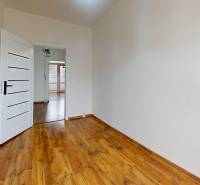 A room with white walls and a wooden decor floor in a 3-room apartment.