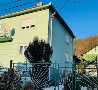 A family house in Horná Ves with a colorful facade and a garden, sunny day.